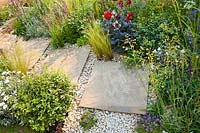 Decorative paving with stones and gravel Plants are Dahlia 'Romeo', Stipa tenuissima, Briza media and Convolvulus cneorum.