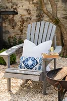 Adirondack chair with cushions next to firepit