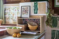 Old fashioned vintage kitchen area for vegetable preparation in garden room, filled with gardening paraphanalia and vintage wall art