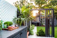 View across outdoor kitchen with raw food on the worktop ready for BBQ.