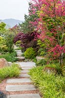 Stone stepping stones form path set in a gravel garden. A Japanese Reflection garden, RHS Malvern Spring Festival, 2016. Design: Peter Dowle and Richard Jasper - Howle Hill Nursery