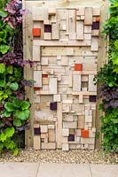 A vertical gardening living wall and modern wooden fence made from old timber cut offs. For The Love Of It, RHS Tatton Park Flower Show, 2017. garden Designer: Pip Prober