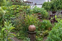 A sculpture by Rosemarie Barr in informal country garden border 