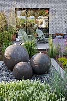 Round stone water feature in contemporary garden.
