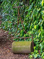 A vintage garden roller at East Ruston Old Vicarage garden, Norfolk, UK. 