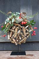 Wooden globe decorated with crab apples and evergreen foliage. Styling: Marieke Nolsen
