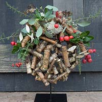 Wooden globe decorated with crab apples and evergreen foliage. Styling: Marieke Nolsen