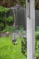 A handmade windchime made from repurposed forks and spoons and blue glass marbles