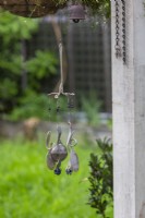 A handmade windchime made from repurposed forks and spoons and blue glass marbles