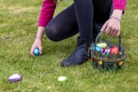 Child collection colourful chocolate eggs in basket at Easter
