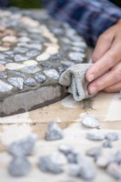 Wiping excess grout off the edge of the stepping stone