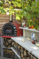 Outdoor kitchen with red pizza oven 