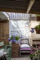 Interior filled with vintage and antique furniture, prints and potted Hyacinth flowers 