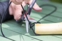 Cutting off excess string on one side of the knot