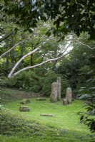 Granite standing stones in shady woodland garden