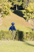 Woman in blue dress and headdress walking in the park. Lisbon, Portugal, September. 
