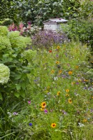 Natural planting with a bee hive. RHS COP26 Garden, RHS Chelsea Flower Show 2021