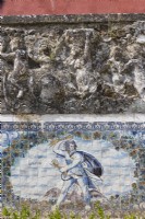 Detail of the wall of the Formal Garden with glazed tiles or Azuljelos depicting the harvest and raised sculpture of figures in wall above. Lisbon, Portugal, September.