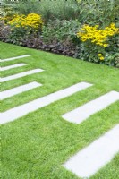 Lawn with several long step stones.