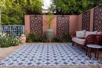 Moroccan style patio in suburban garden with decorative screens on wall