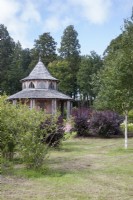 Wooden garden-shelter/summerhouse in Arboretum at Dumfries House.  September. Summer.