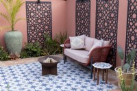 Moroccan style patio in suburban garden with decorative screens on painted wall