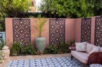 Moroccan style patio in suburban garden with decorative screens on wall