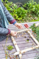 Woman fixing twigs to the frame