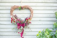 Heart wreath hanging on faded green wooden wall
