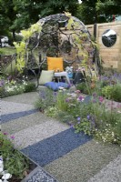 'On Your Bike!' at BBC Gardener's World Live 2021 - veoldrome made from rubber leading around a cycling themed garden with shaded seating area made from old wheels