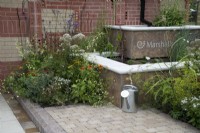 'The Marshalls Garden' at BBC Gardener's World Live 2021 - urban garden with raised two tier pond bordered by decorative brick wall with built in insect hotels 