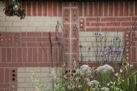 'The Marshalls Garden' at BBC Gardener's World Live 2021 - decorative brick wall with in built insect hotels, bordered by perennials