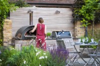 Lisa, garden owner baking pizza in the outdoor pizza oven. 