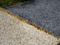Edging detail of thick stemmed bamboo tubes separating two colours of gravel pathway . Floriade Expo 2022 International Horticultural Exhibition Almere Netherlands