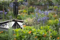 Water feature and mixed planting in 'Abigail's Footsteps' Show Garden at the RHS Malvern Spring Festival 2022 - Designer Rick Ford - Silver Medal Winner