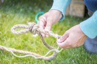 Woman binding the end of a piece of rope