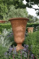 Bespoke terracotta urn with impressed thistle patttern sitting amongst Nepeta 'Six Hills Giant' and Cynara cardunculus in The RNLI Garden - Designer: Chris Beardshaw - Sponsor: Project Giving Back -