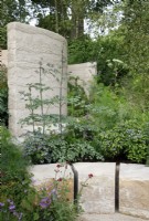 View of the purbeck stone blocks creating a sitting area in the The Mind Garden with planting - Designer: Andy Sturgeon - Sponsor: Project Giving Back.