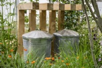 Wooden enclosure for metal compost bins hidden under wooden slots and planting - The Core Arts Front Garden Revolution Garden
