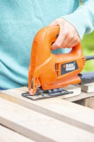 Woman sawing the planks to the correct lengths