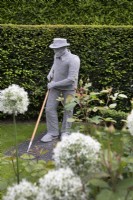 Wire sculpture of a man gardening by Derek Kinzett in the front garden at Hamilton House garden in May 