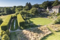 Formal garden of hornbeam allee, rill, circular lawn and terracing in Somerset in July