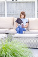 Woman sitting on a settee reading a book