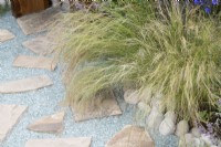 Stipa tenuissima - Mexican feather grass and Recycled glass stone pathway on the Journey Home garden RHS Tatton Park Flower Show 2022 - Designed by Rachael Bennion and Petrus Community