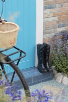 Wellington boots by a front door on the Journey Home garden RHS Tatton Park Flower Show 2022 - Designed by Rachael Bennion and Petrus Community