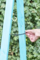 Woman attaching a chain inbetween both sides of the frame