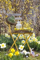 Spring arrangement with wreath of willow twigs, daffodils, hanging moss heart and Easter eggs.