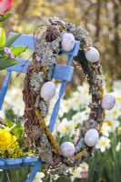 Easter wreath made of beech branches, lichens and coloured eggs.