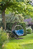 Free-standing swing seat on lawn.