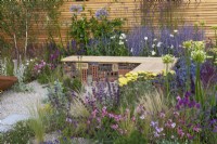 A sustainable, low maintenance gravel garden filled with drought tolerant plants to attract pollinators, such as salvia, achillea, sea pinks, echinops, fleabane, perovskia, agapanthus, sea hollies and catmint.